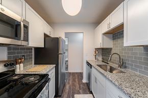 Webster townhouse for rent - A kitchen with a black stove top oven and a black refrigerator.
