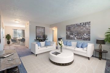 Webster townhouse for rent - A living room with a white couch, a coffee table, and a painting on the wall.