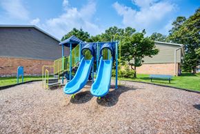 Rochester apartment for rent - A playground with a blue slide and yellow handrails.
