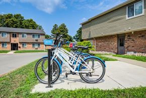 Rochester apartment for rent - A blue bicycle is parked on a stand outside a building.