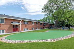 Rochester apartment for rent - a green circle of grass in front of a brick building