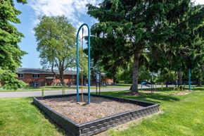 Rochester apartment for rent - a playground in a park with trees and a swing set