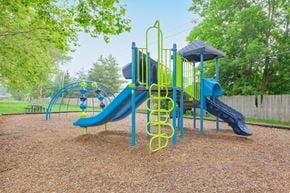 Rochester apartment for rent - a playground with a swing set and slides at a park