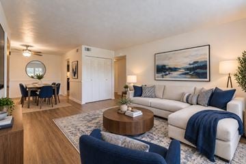 Rochester apartment for rent - A living room with a white couch and blue chairs.