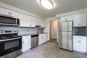 Rochester apartment for rent - a kitchen with stainless steel appliances and white cabinets