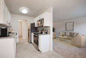 Fairport apartment for rent - a kitchen and living room with a stove refrigerator and microwave
