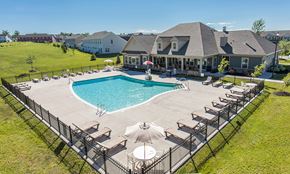 Watertown townhouse for rent - a swimming pool with chairs and umbrellas in front of a house