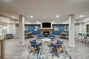 Rochester apartment for rent - a clubhouse with tables and chairs and a fireplace
