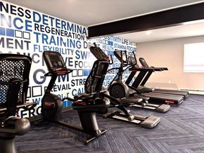Henrietta apartment for rent - A gym with a row of stationary bikes in front of a wall with fitness related words.