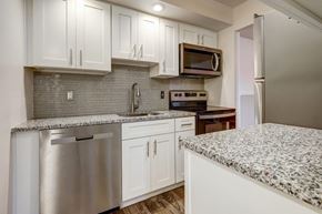 Rochester apartment for rent - a white kitchen with granite counter tops and stainless steel appliances