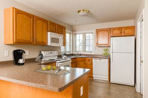 Webster apartment for rent - A kitchen with wooden cabinets and a white refrigerator.
