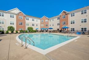 Webster apartment for rent - A large swimming pool is surrounded by apartment buildings.