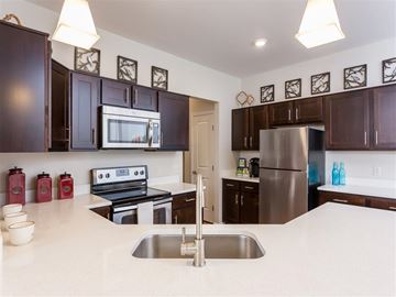 Webster apartment for rent - A kitchen with dark brown cabinets and a stainless steel refrigerator.