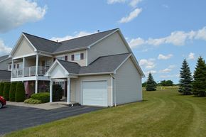Avon apartment for rent - A large house with a garage and a car parked in front.