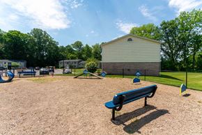 Penfield apartment for rent - A park with a blue bench and a playground.