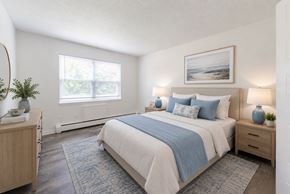 Penfield apartment for rent - A bedroom with a large bed and a window.