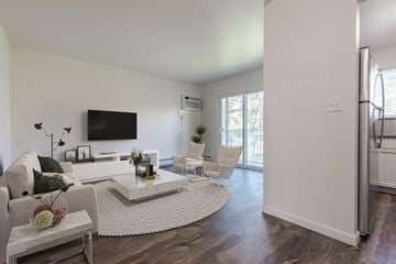 Penfield apartment for rent - a white living room with a white rug and a television