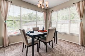 Coraopolis apartment for rent - a dining room with large windows and a table and chairs