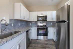 Coraopolis apartment for rent - A kitchen with a stove top oven and a refrigerator.