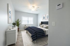 Rochester apartment for rent - a bedroom with a bed and a ceiling fan