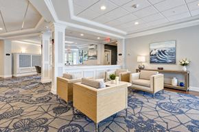 Rochester apartment for rent - A spacious waiting room with patterned carpeting and a large painting on the wall.
