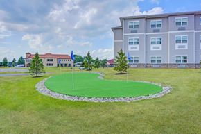 Rochester apartment for rent - a round lawn with two flags in front of a building