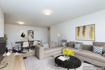 Oakland apartment for rent - A living room with a grey couch and a coffee table with flowers on it.