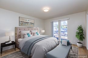 Oakland apartment for rent - A bedroom with a large bed and a window overlooking a balcony.
