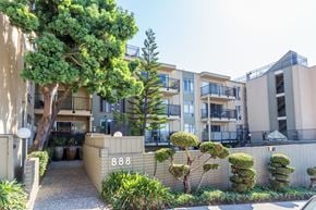 Oakland apartment for rent - A building with the number 888 on it is surrounded by greenery.