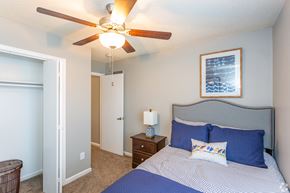 Lenexa townhouse for rent - a bedroom with a bed and a ceiling fan