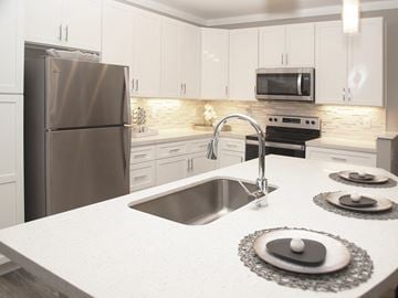 Dayton apartment for rent - a white kitchen with stainless steel appliances and a sink