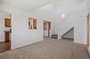 Grand Rapids apartment for rent - A spacious living room with a staircase leading to the upper floor.