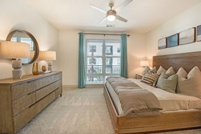 Jacksonville apartment for rent - a bedroom with a large bed and a ceiling fan