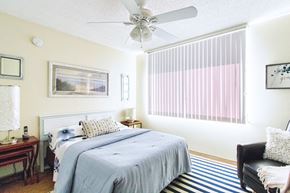 Jacksonville apartment for rent - spacious bedroom with wood-style floor, large window, and ceiling fan