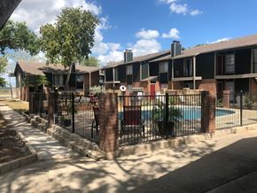 New Braunfels apartment for rent - an apartment building with a pool behind a fence