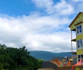Crozet apartment for rent - A yellow house with a red fence in front of a mountain.