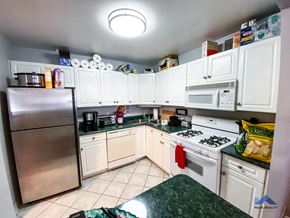 Chicago apartment for rent - A kitchen with white cabinets and a stainless steel refrigerator.