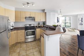 Calgary apartment for rent - Kitchen with tile floors, stove and bar counter