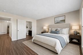 Victor apartment for rent - A bedroom with a large bed and a painting on the wall.