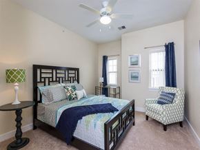 Rochester apartment for rent - a bedroom with a bed and a ceiling fan