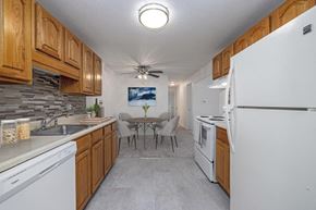 Fairport apartment for rent - a kitchen with white appliances and a dining room with a table
