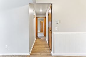 Jenison apartment for rent - a hallway with white walls and wood flooring and a door to a bedroom