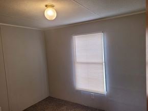 Shawnee house for rent - A room with a window covered by white blinds and a light bulb on the ceiling.