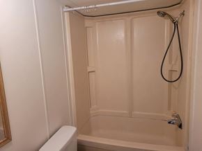 Shawnee house for rent - A white bathroom with a shower and toilet.