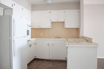 Salt Lake City apartment for rent - A white refrigerator is in a kitchen with white cabinets.