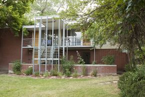 Salt Lake City apartment for rent - A house with a red brick exterior and a white metal structure on the upper floor.