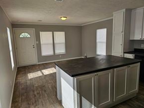 Shawnee house for rent - A kitchen with a black counter top and white cabinets.