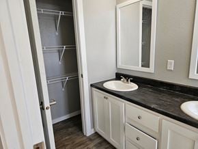 Shawnee house for rent - A bathroom with a sink, mirror, and open cabinet.
