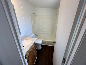 Shawnee house for rent - A small bathroom with a toilet, sink, and bathtub.