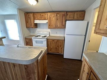 Shawnee house for rent - A kitchen with wooden cabinets and a white stove top oven.